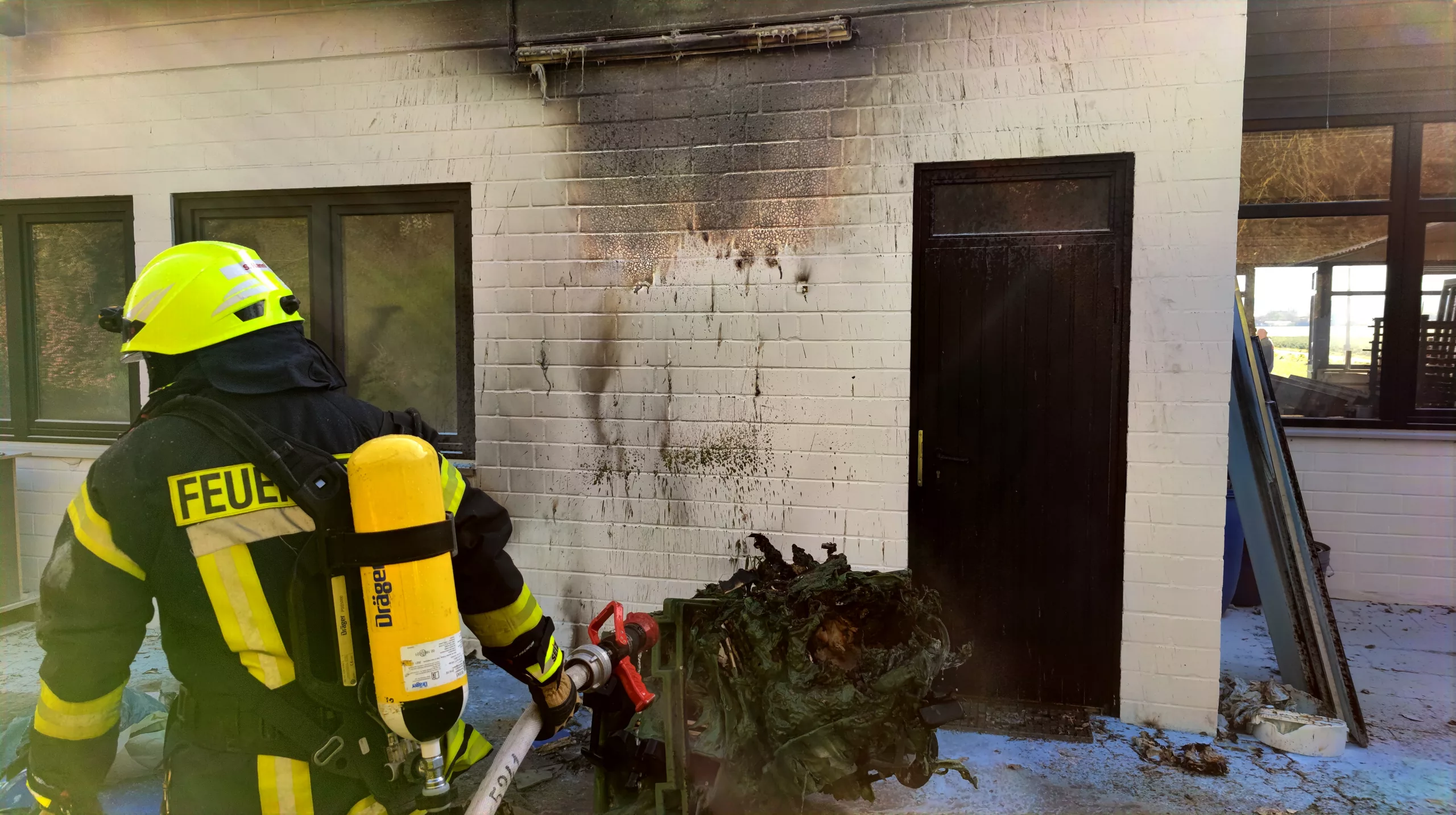 Brennt Mülltonne an Gebäude